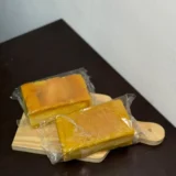 Bolo barra branca artesanal 350g embalado Delícias da Vó Dulce sobre tábua de madeira