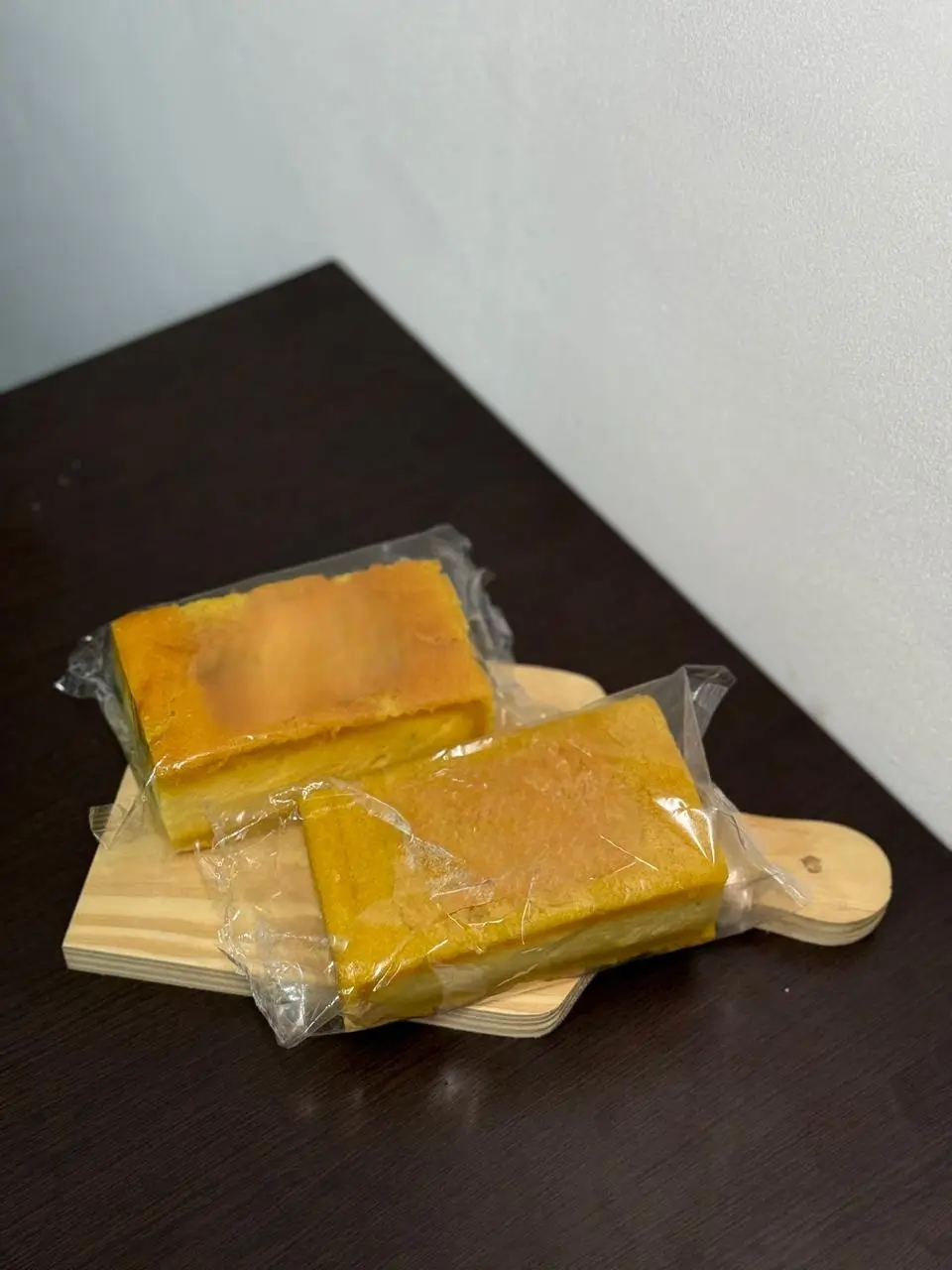 Bolo barra branca artesanal 350g embalado Delícias da Vó Dulce sobre tábua de madeira